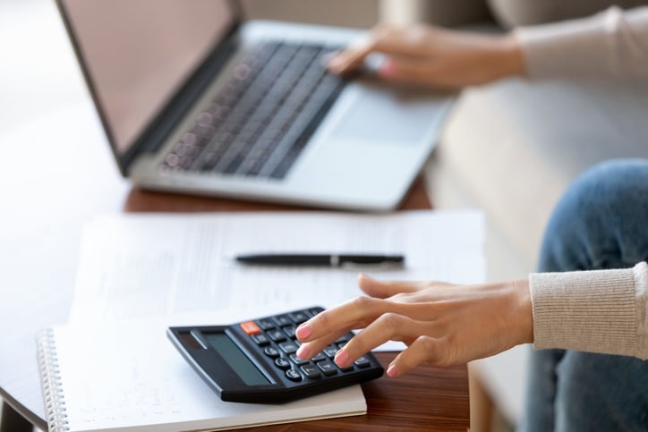 Businesswoman using calculator and laptop for budget cost management - financial prep
