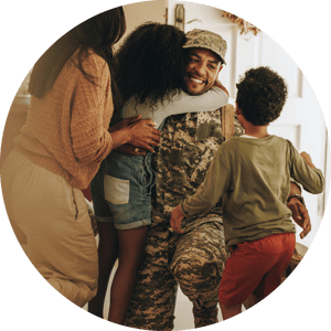 A family hugs their father who is a member of the military.