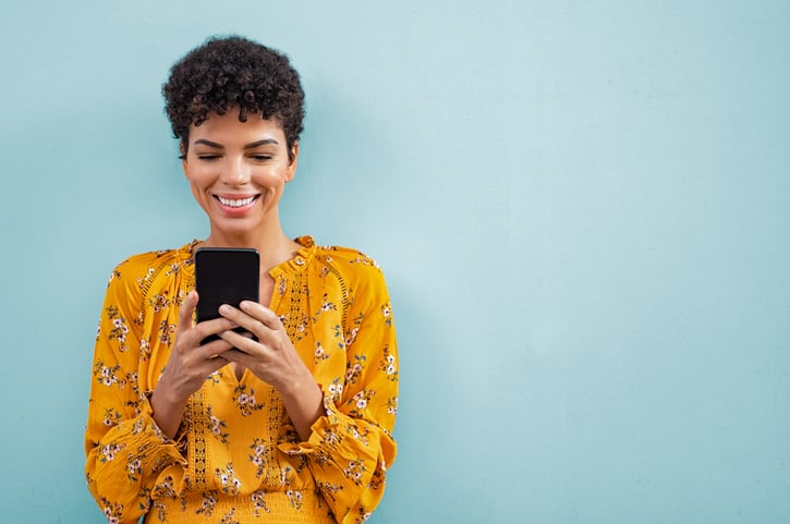Woman smiles at her phone