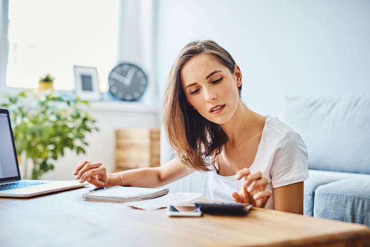 Young woman looking at calculator on the computer benefits